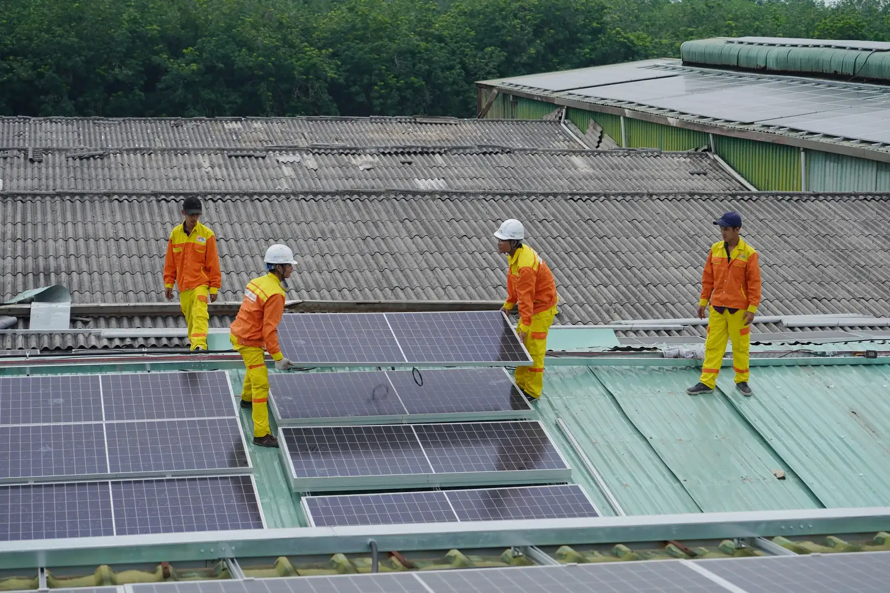 Installers fitting solar panels to a house roof in the Okanagan